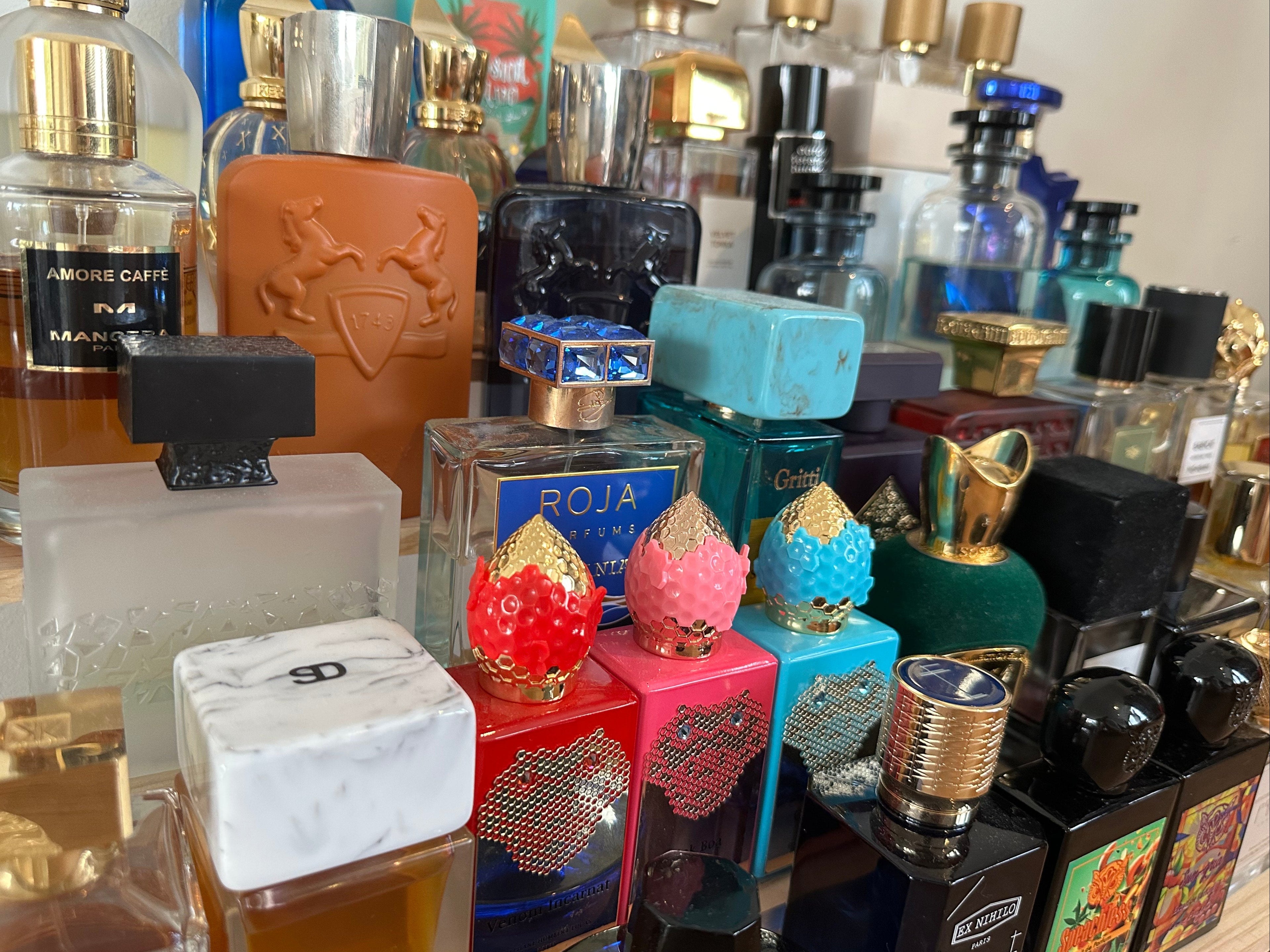 Collection of various perfume bottles with different designs and colors on a table.